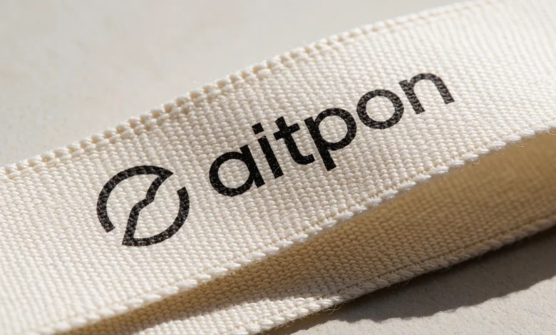 A close-up of a high-quality cotton ribbon with a printed logo, showing the texture of the fabric, the logo clearly visible in a simple sans-serif font, the ribbon slightly folded to reveal depth, soft natural lighting, neutral background, no text or numbers in the image
